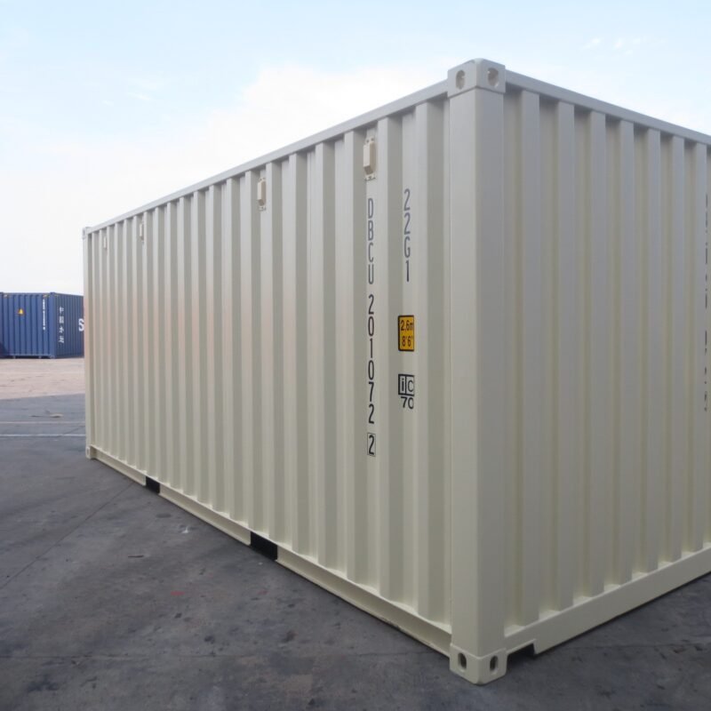 Container 20 pieds blanc crème posé sur aire de stockage, vue latérale