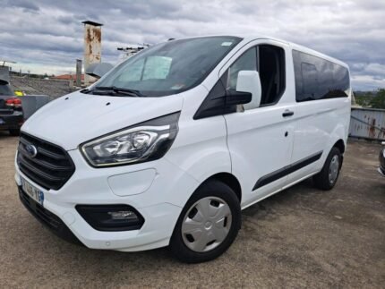 vue avant droite du minibus blanc garé sur parking