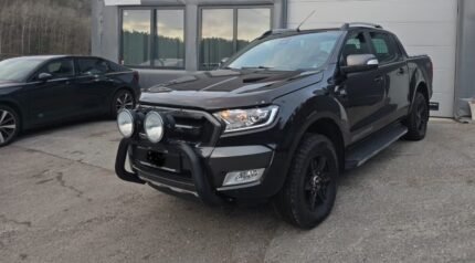 Vue avant trois-quarts du pick-up noir équipé d'un arceau et phares additionnels