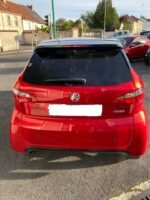 Vue latérale montrant la ligne et les vitres teintées du Coupé rouge