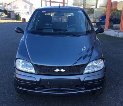 Vue avant gauche du microcar sur parking, phare et pare-chocs visibles