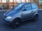 Vue latérale du microcar montrant la portière et les jantes