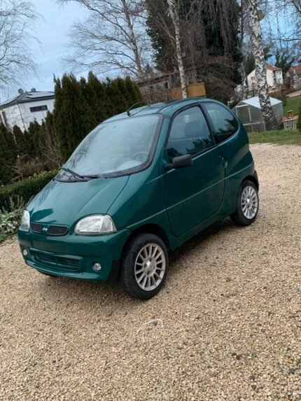 Vue avant droite de la microvoiture Ambra GLX garée en extérieur