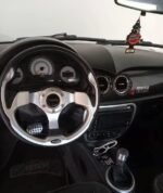 Gros plan sur la portière et la poignée du microcar gris