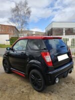 Gros plan sur la jante aluminium noire et l'état de la peinture