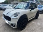 Vue avant droite microcar blanche nacrée garée en extérieur