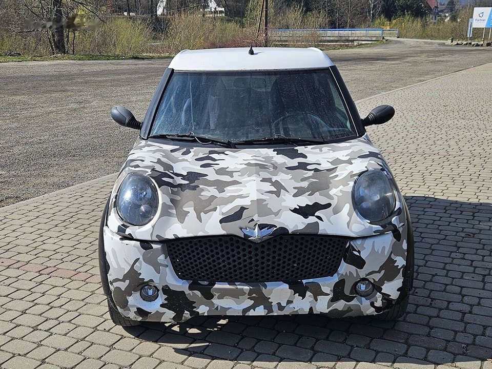 Profil latéral gris, microcar compacte stationnée en extérieur
