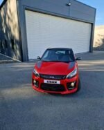 Profil latéral montrant la carrosserie rouge et les lignes compactes de la voiture