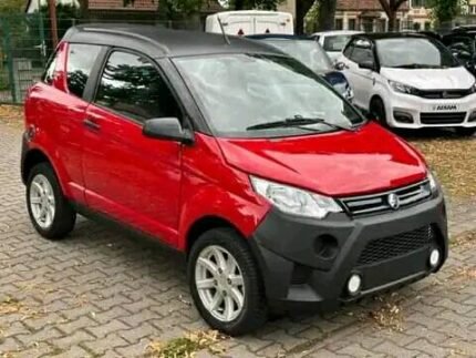 Vue avant trois-quarts du véhicule microcar garé en extérieur