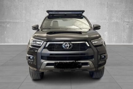 Vue avant gauche du pick-up noir avec arceau et barre LED, plateau plat et protections