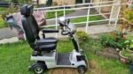 vue latérale du scooter Quingo Confort+ en extérieur montrant la structure 5 roues