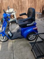 Vue latérale du scooter montrant les roues et le châssis robuste
