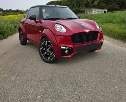 Vue avant gauche de la microcar verte stationnée, éclairage extérieur et pare-chocs visibles
