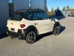 Vue latérale du véhicule blanc montrant la carrosserie et les jantes