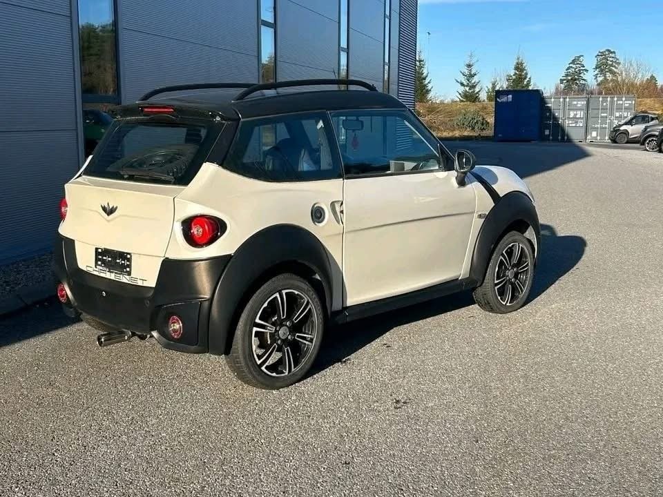 Vue latérale du véhicule blanc montrant la carrosserie et les jantes