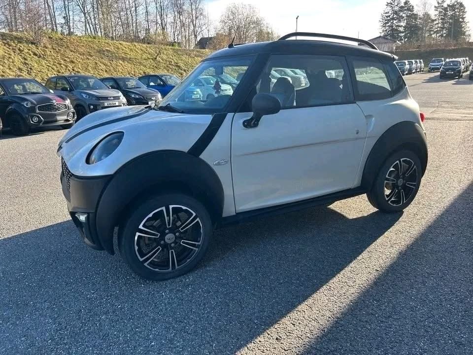 Vue avant droite du véhicule blanc garé, mise en valeur de la carrosserie