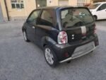 Vue latérale du véhicule microcar sur fond urbain