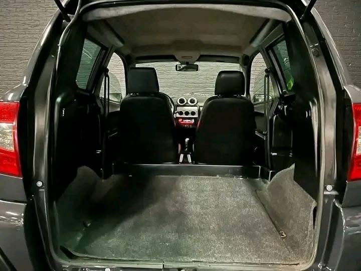 Vue latérale du véhicule montrant l'état de la carrosserie et des jantes