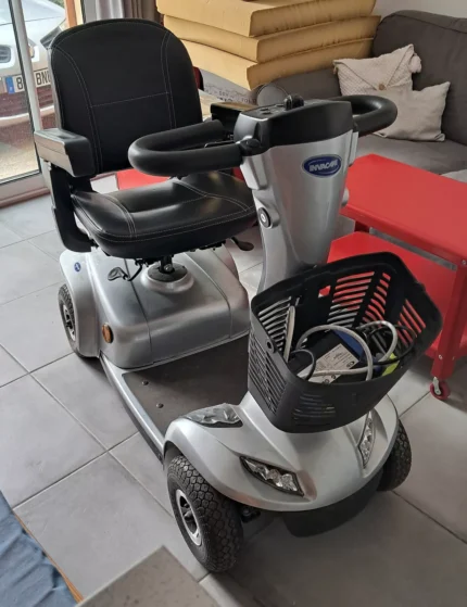 Scooter Invacare Leo vu de trois quarts, couleur gris, siège pivotant relevé